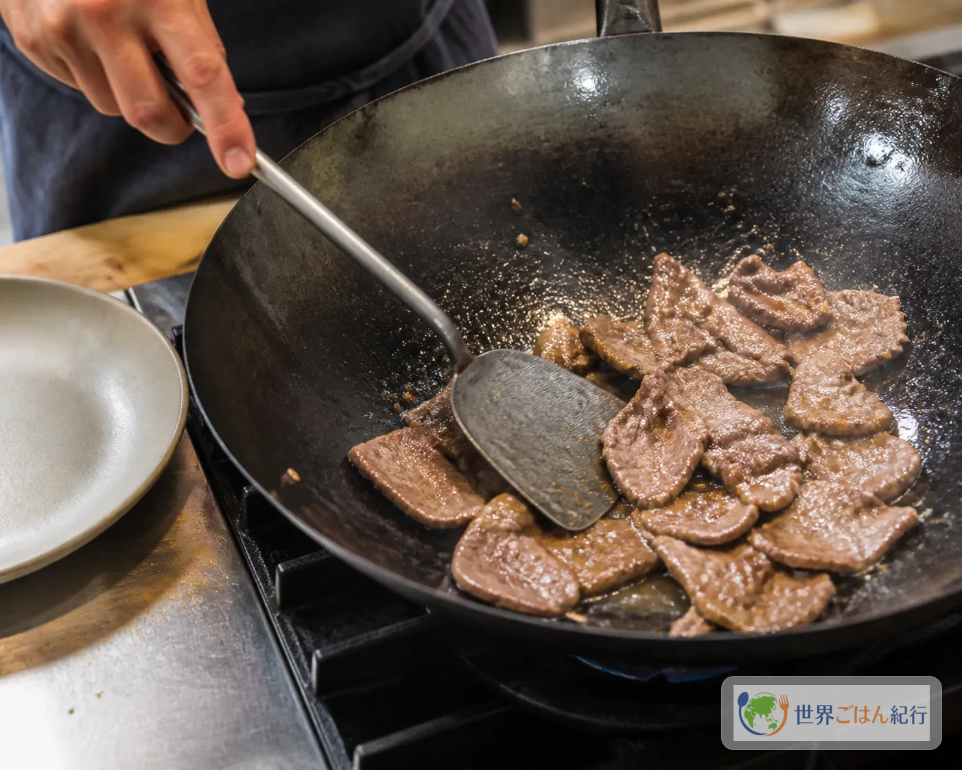 中強火のフライパンで牛肉の薄切りを焼き、表面に焼き色をつけている途中